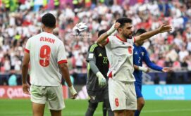 صورة مقربة للاعب كرة قدم يمسك ساقه المصابة في الملعب