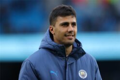 رودري لاعب مانشستر سيتي وقميص ريال مدريد مع شعار النادي
