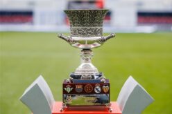شعار كأس السوبر الإسباني مع خلفية لملعبي برشلونة وريال مدريد