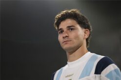 جوليان ألفاريز بقميص أتلتيكو مدريد وخلفه شعار ريال مدريد