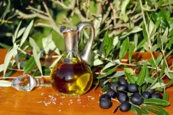 زجاجة زيت زيتون بكر ممتاز مع ثمار الزيتون وأوراقها، ترمز لصحة القلب.