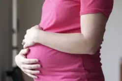 امرأة حامل تفكر في تناول أشياء غير غذائية مثل الطباشير أو التراب، مع خلفية طبية توضح اضطراب بيكا.