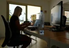 موظف يعمل من المنزل بابتسامة، يظهر راحة وسعادة، مما يعكس تحسن الصحة النفسية