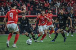 شعار الأهلي والزمالك معًا في خلفية ملعب كرة قدم يرمز للقمة المصرية