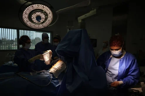 صورة مقربة لعملية جراحية لاستئصال الزائدة الدودية مع خلفية توضح الجهاز الهضمي