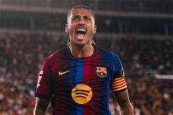 رافينها يرتدي قميص برشلونة مع صورة رونالدينيو في الخلفية